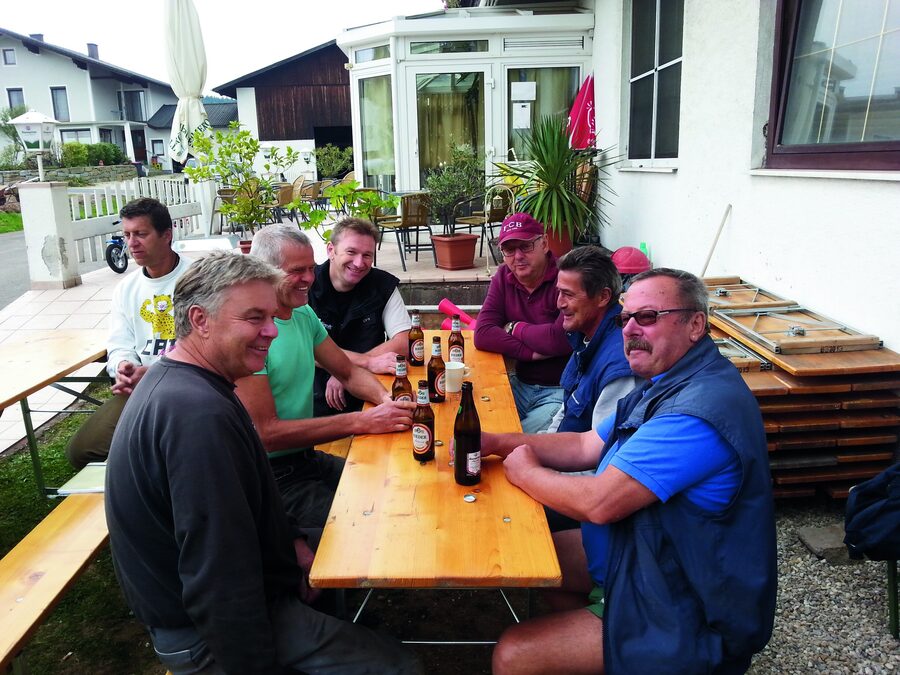 Helfer sitzen nach dem Arbeitseinsatz am Biertisch