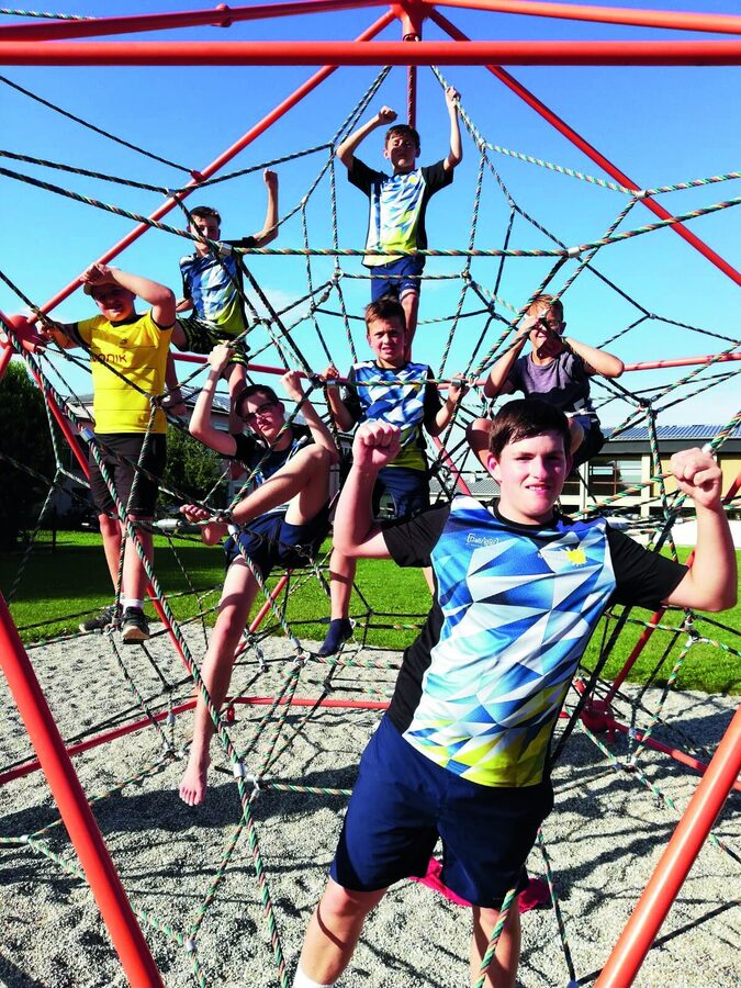 Jugendlicher klettert im Klettergerüst